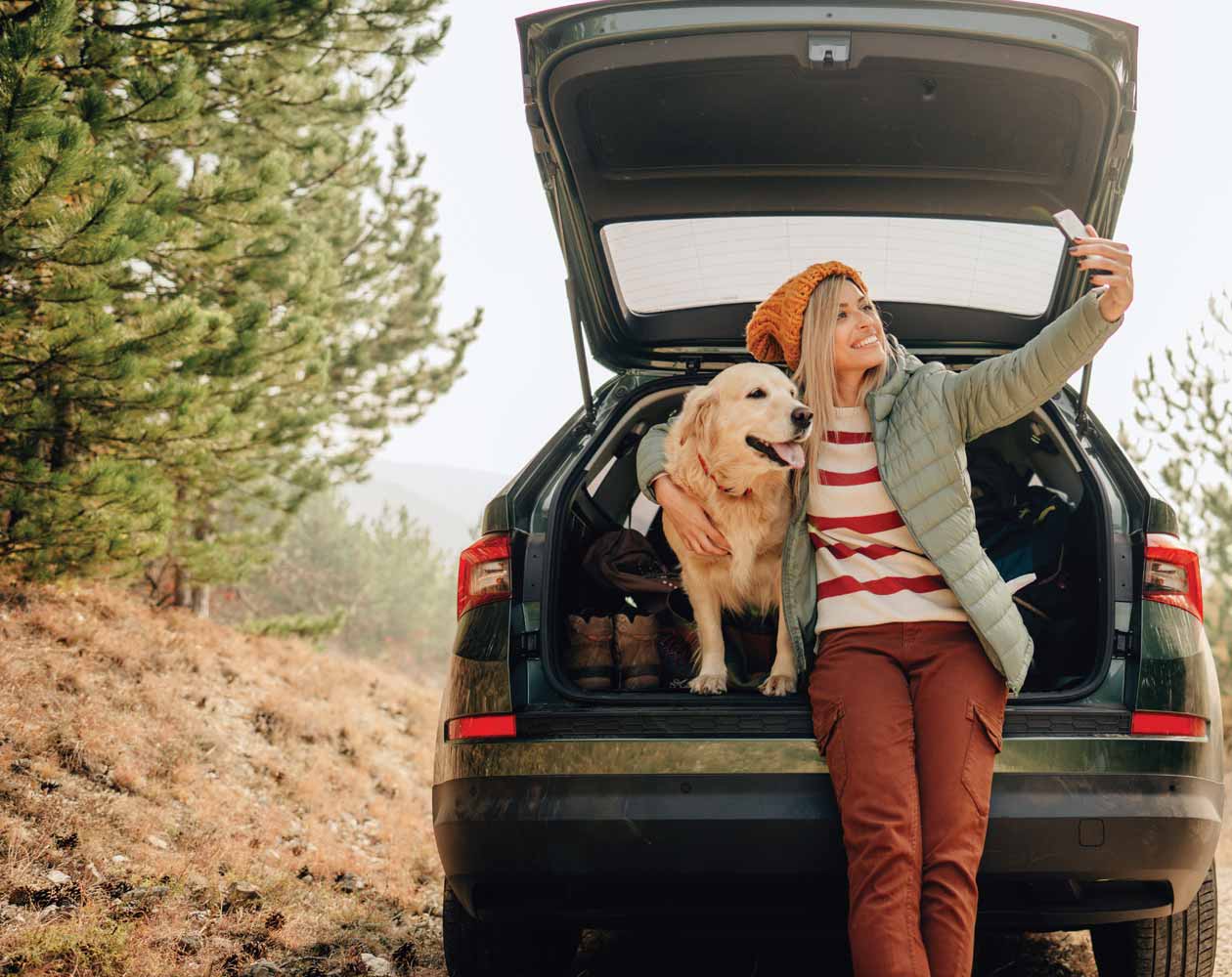 Girling taking a selfie with her dog in the back of her car