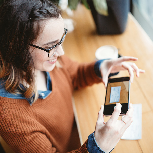 A woman utilizing the remote deposit feature on her mobile phone