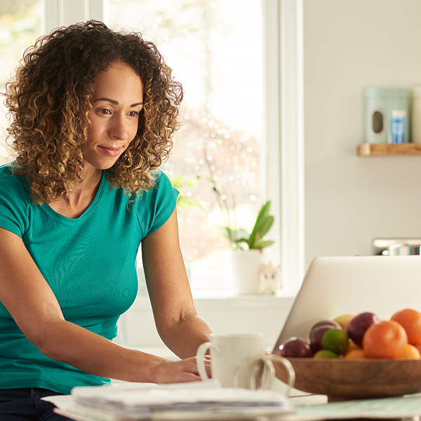 A woman checking her monthly statements via online banking on her laptop