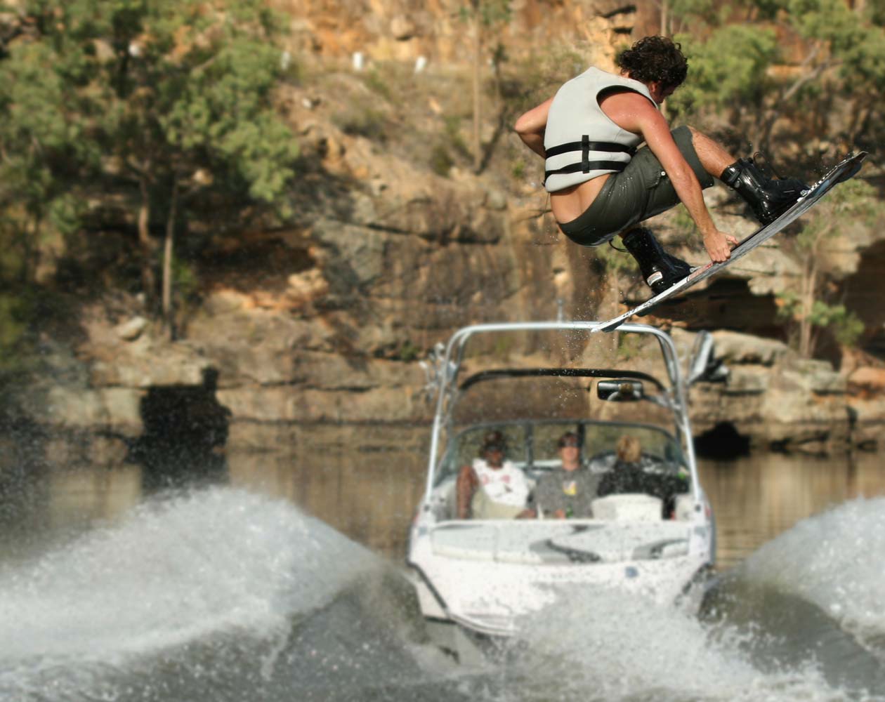 Wake boarder flying through the sky behind a boat